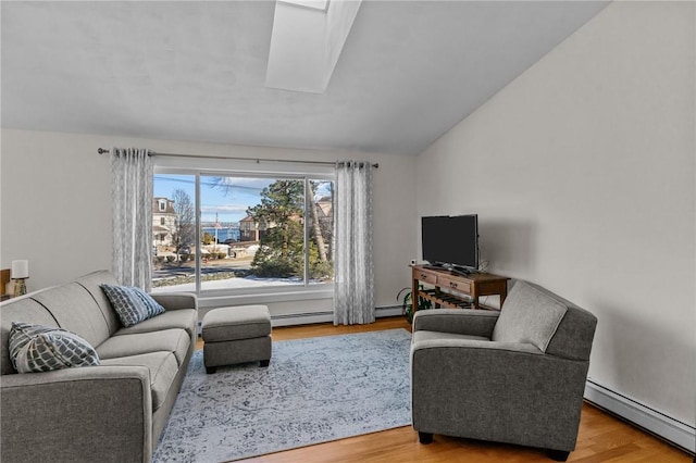 living area with vaulted ceiling, baseboard heating, and wood finished floors