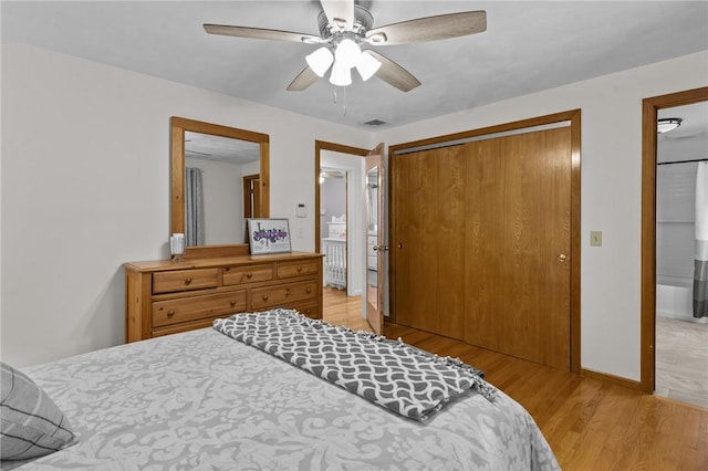 bedroom featuring visible vents, baseboards, ceiling fan, light wood-style floors, and a closet