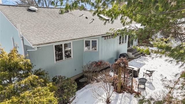 view of property exterior featuring entry steps, a patio, and roof with shingles