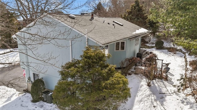 view of snow covered exterior featuring a shingled roof