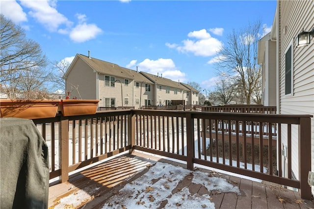 snow covered deck featuring a residential view