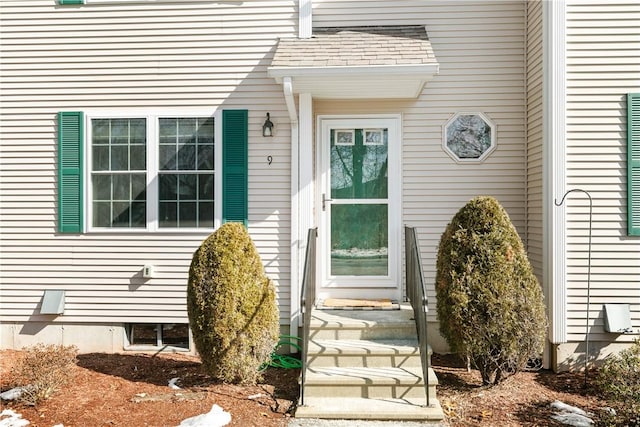 doorway to property featuring roof with shingles