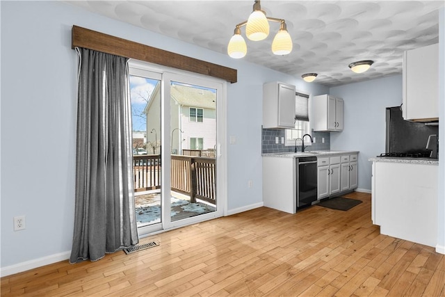 kitchen with decorative light fixtures, backsplash, freestanding refrigerator, white cabinets, and dishwasher