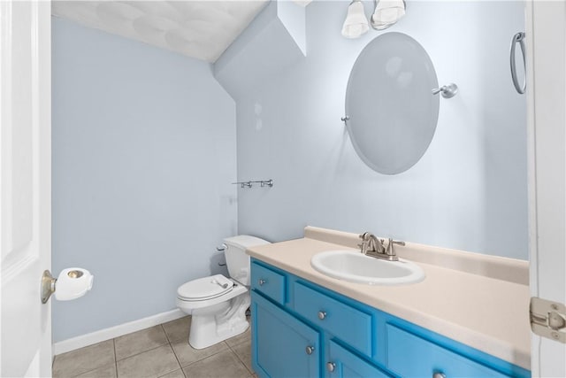 bathroom featuring baseboards, vanity, toilet, and tile patterned floors