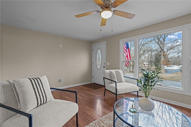 sitting room with ceiling fan, dark wood finished floors, and baseboards