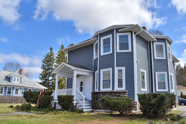 view of front of home featuring stone siding and fence