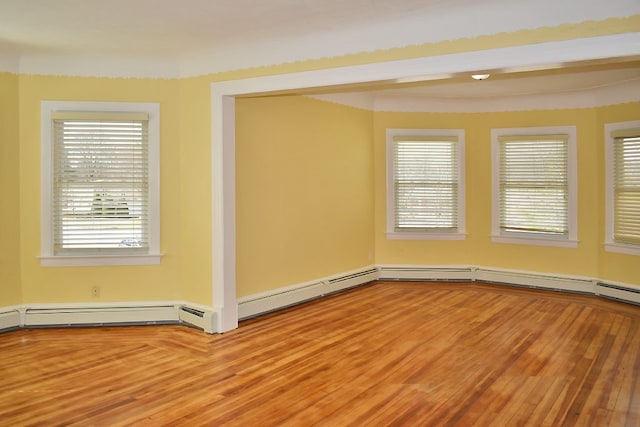 spare room with a wealth of natural light and wood finished floors