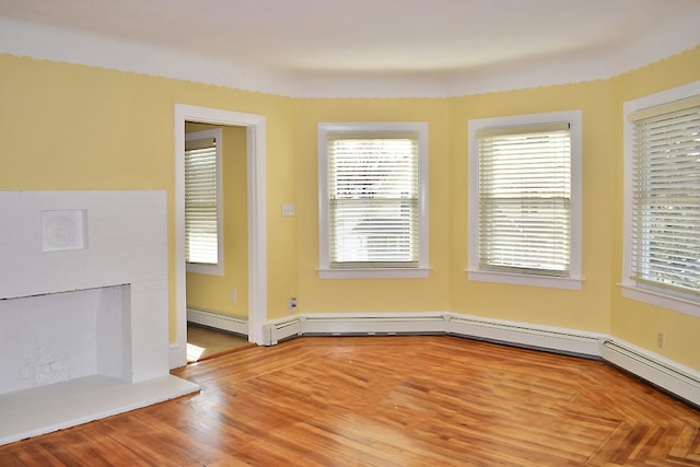 unfurnished room featuring a fireplace with raised hearth and wood finished floors