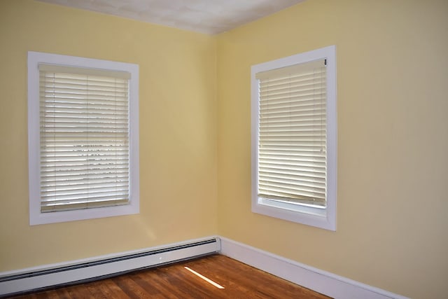 unfurnished room with dark wood-type flooring and a baseboard radiator