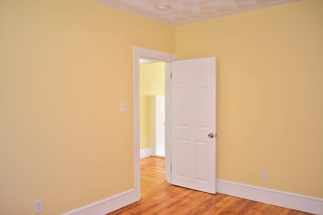 unfurnished room with baseboards and wood finished floors