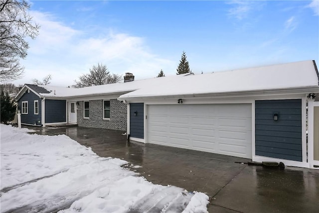 single story home with driveway, a chimney, and an attached garage