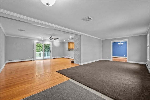 unfurnished living room with visible vents, baseboard heating, crown molding, and wood finished floors