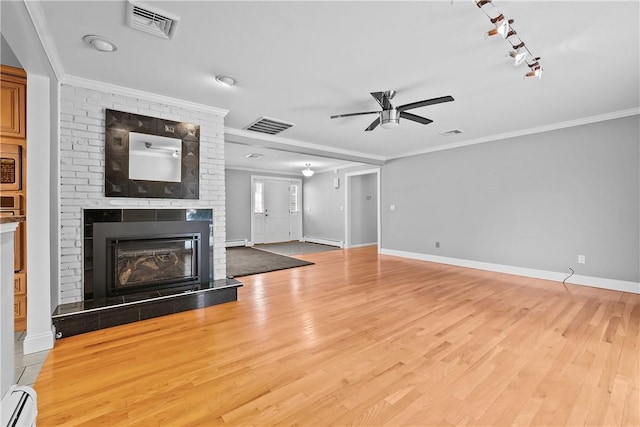 unfurnished living room featuring visible vents, a fireplace, a baseboard heating unit, and crown molding