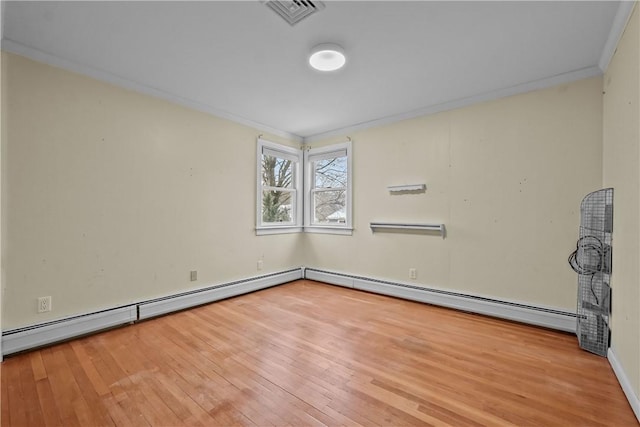 unfurnished room with ornamental molding, a baseboard heating unit, visible vents, and light wood-style floors