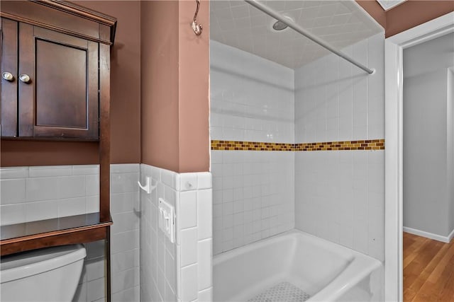 full bathroom with toilet, washtub / shower combination, and wood finished floors