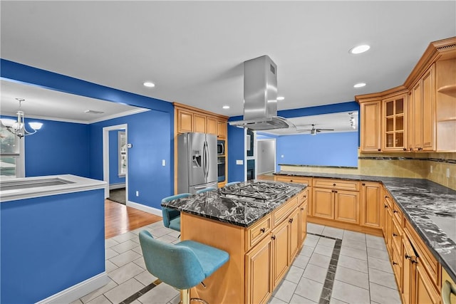 kitchen with island exhaust hood, a breakfast bar area, glass insert cabinets, appliances with stainless steel finishes, and a kitchen island