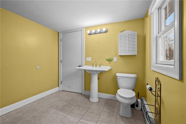 bathroom featuring a baseboard heating unit, baseboards, toilet, and tile patterned floors