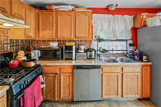 kitchen with light countertops, dishwasher, black gas range oven, and a sink