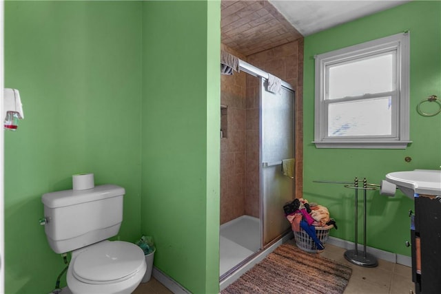 full bathroom featuring tile patterned flooring, toilet, vanity, baseboards, and a stall shower