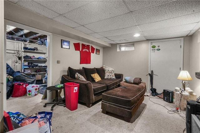 living area featuring carpet flooring and a drop ceiling