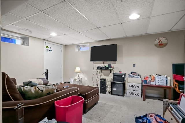 carpeted living room featuring a drop ceiling