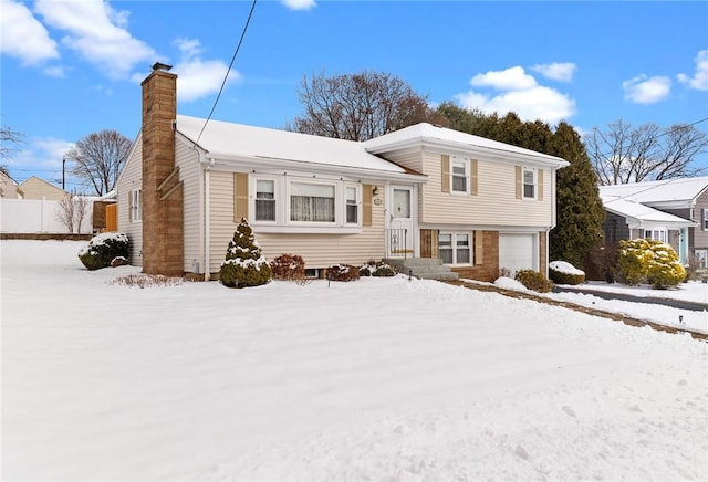 split level home featuring a garage and a chimney