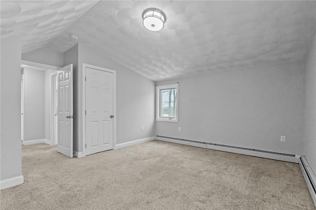 additional living space with light carpet, a baseboard radiator, lofted ceiling, and baseboards