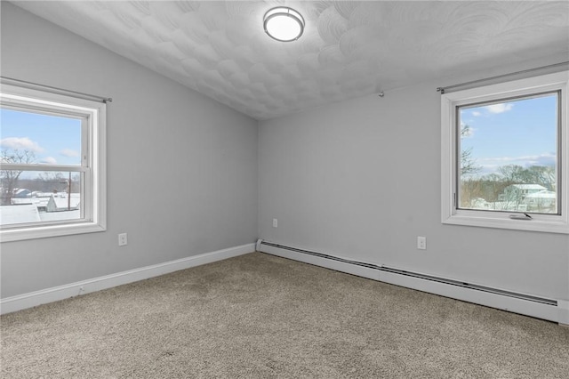 empty room with carpet floors, plenty of natural light, vaulted ceiling, and baseboard heating