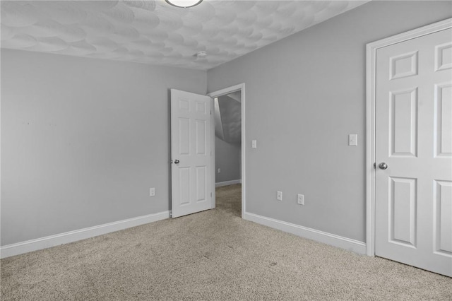 unfurnished bedroom with carpet and baseboards