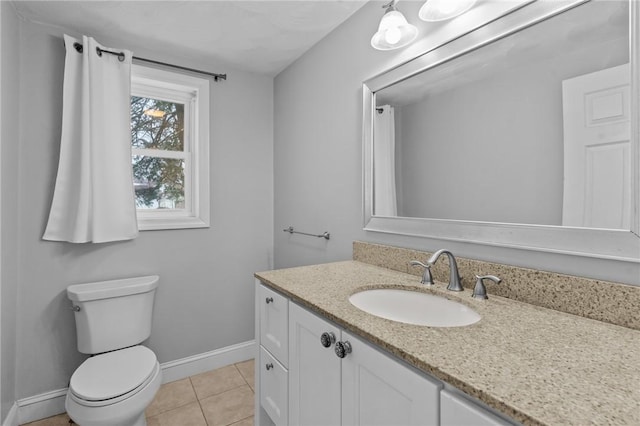 half bathroom with baseboards, toilet, vanity, and tile patterned floors