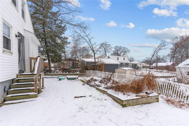 yard covered in snow with fence and a residential view