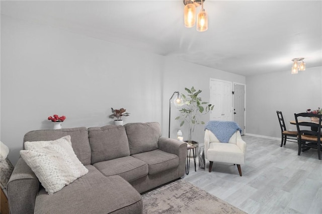 living area featuring baseboards and light wood finished floors