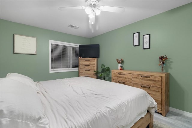 bedroom featuring visible vents, ceiling fan, light wood-style flooring, and baseboards