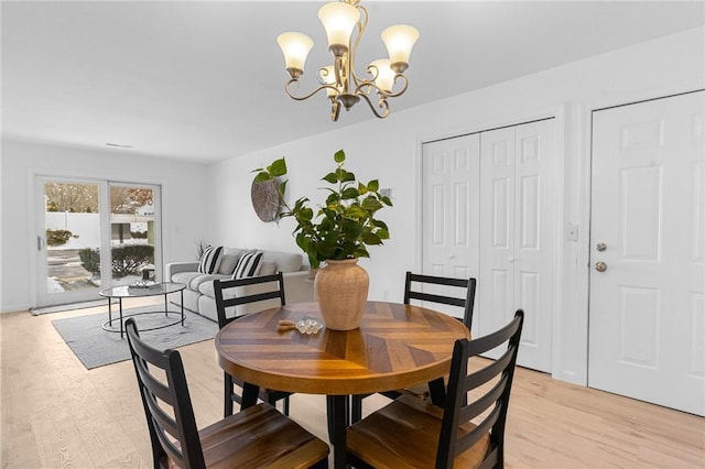 dining room featuring light wood-style flooring and an inviting chandelier