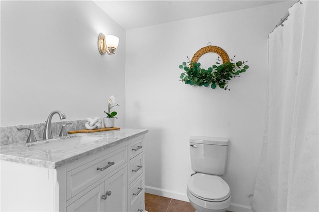 bathroom featuring toilet, tile patterned flooring, vanity, and baseboards