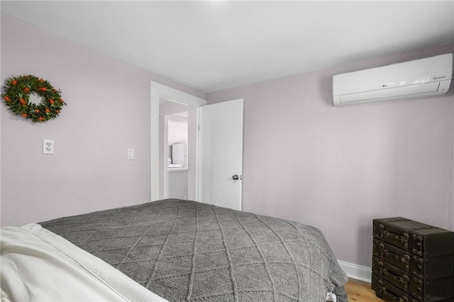 bedroom with a wall mounted air conditioner and wood finished floors