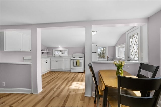 dining room with lofted ceiling and light wood finished floors