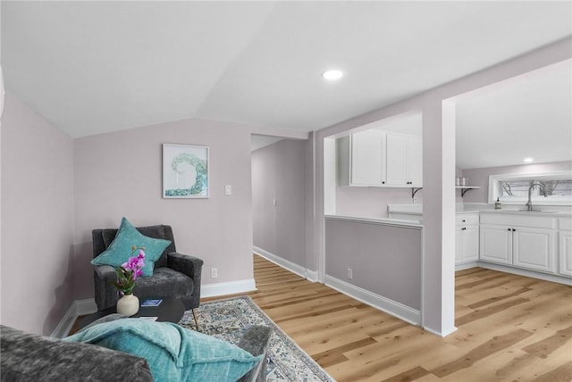 sitting room featuring light wood-type flooring, baseboards, vaulted ceiling, and recessed lighting