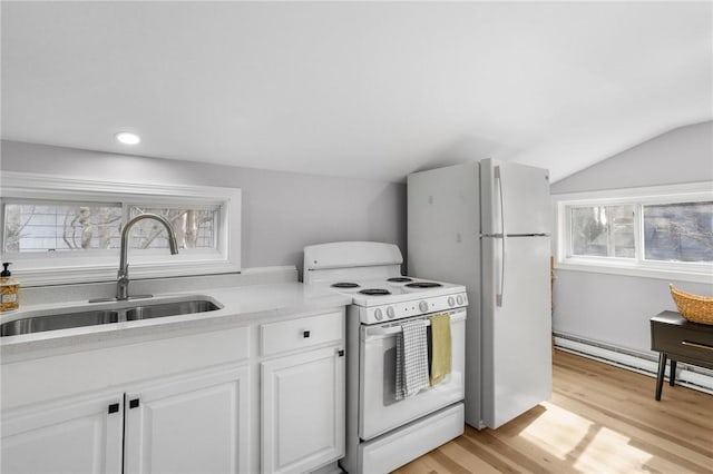 kitchen with lofted ceiling, light countertops, white cabinetry, a sink, and white appliances