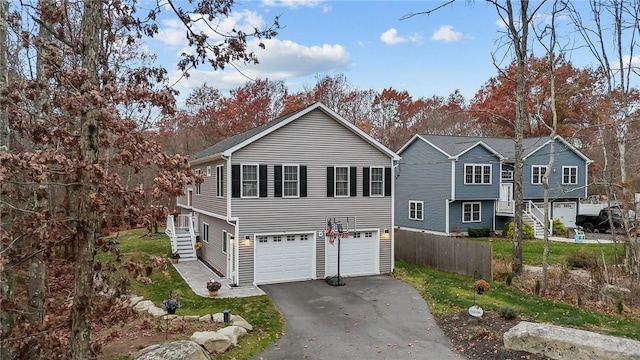 view of front of home featuring aphalt driveway, fence, and a garage