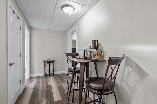 dining area featuring baseboards and dark wood-style flooring