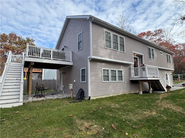 back of property with a yard, stairway, and a wooden deck