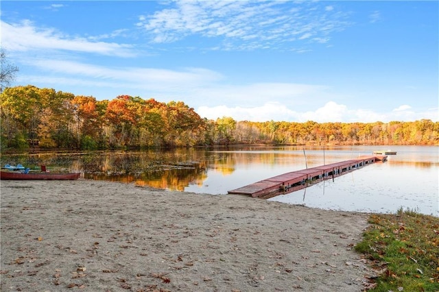 view of dock with a water view and a forest view