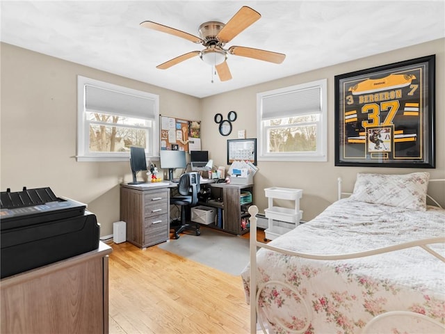 bedroom with a ceiling fan, light wood-style flooring, and baseboards