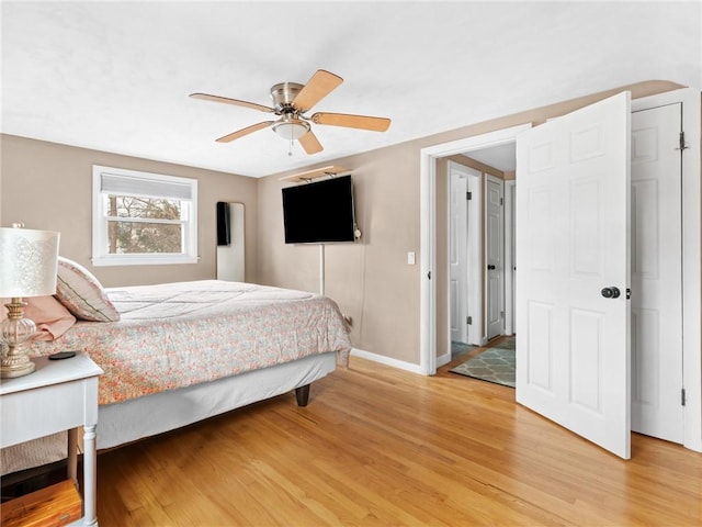 bedroom with baseboards, ceiling fan, and light wood finished floors