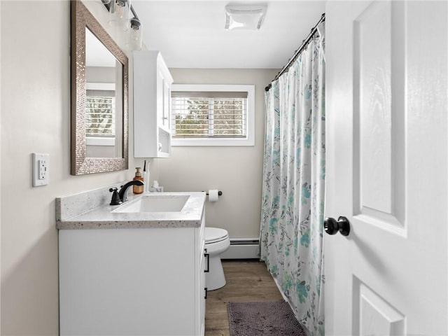 full bath with a shower with shower curtain, toilet, baseboard heating, vanity, and wood finished floors