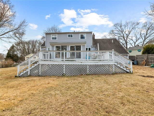 back of house featuring stairway, a wooden deck, fence, and a yard