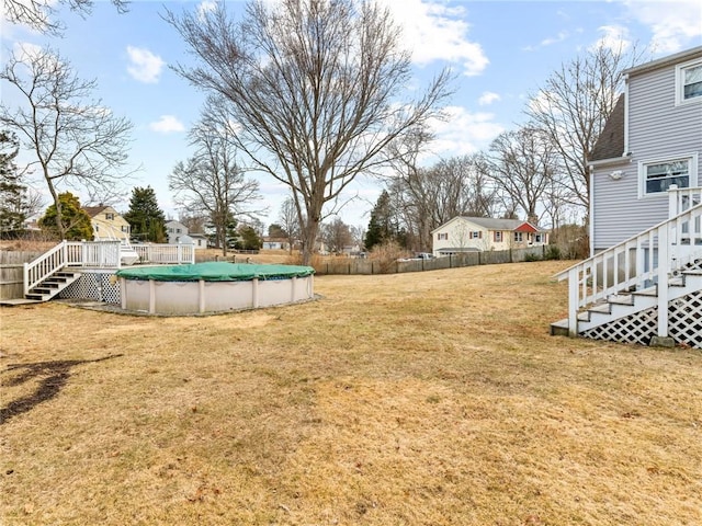 view of yard with fence and a covered pool