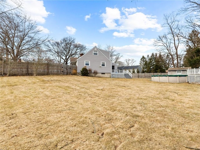 rear view of property with a lawn, a fenced backyard, and a fenced in pool