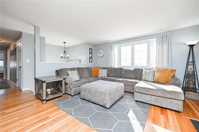 living area with a notable chandelier, baseboards, and wood finished floors